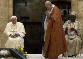 Un representante de religiones orientales reza a sus "dioses". Lo observan Benedicto XVI y un representante de religiones paganas del África.
